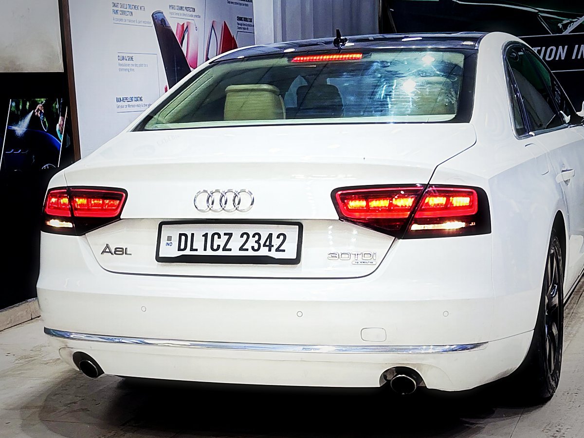 The rear of a white Audi A8 inside Turtle Wax Studio Tellapur